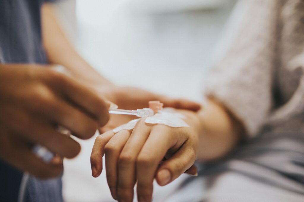 Nurse applying an IV drip to a patient